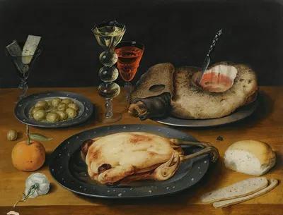 A Still Life Of A Roast Chicken, A Ham And Olives On Pewter Plates With A Bread Roll, An Orange, Wineglasses And A Rose On…