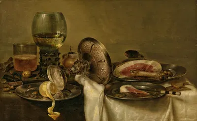 A partially draped table with an overturned tazza, roemer and glass of beer, with a partially peeled lemon and ham on…