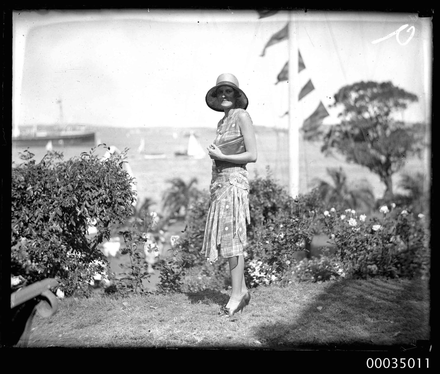 Woman with clutch bag and hat with a regatta in the background by Sam Hood, 1920–1935 — digital art print download